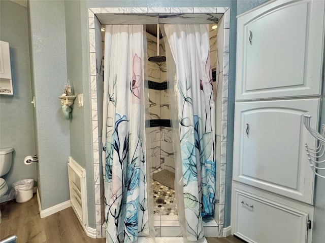 101 Saltgrass Ave, Surfside Beach, TX 77541 - full bathroom featuring baseboards, a stall shower, a textured wall, toilet, and wood finished floors