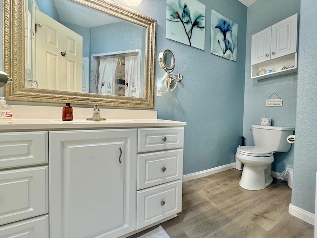 101 Saltgrass Ave, Surfside Beach, TX 77541 - bathroom featuring baseboards, toilet, a textured wall, vanity, and wood finished floors