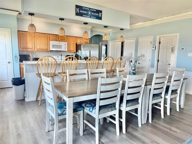 101 Saltgrass Ave, Surfside Beach, TX 77541 - dining area featuring light wood finished floors and crown molding