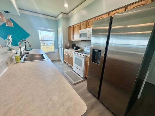101 Saltgrass Ave, Surfside Beach, TX 77541 - kitchen with light wood-style floors, crown molding, white appliances, light countertops, and a sink