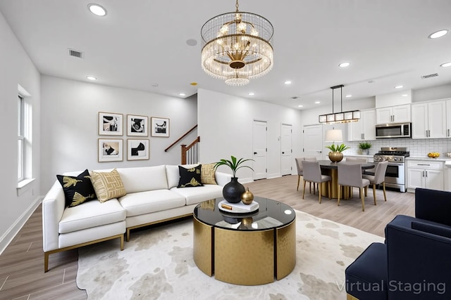 2015 Brackenridge St Unit A, Houston, TX 77026 - living room with light wood-style flooring, baseboards, stairs, a chandelier, and recessed lighting