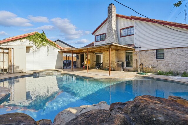 6022 Downwood Forest Dr, Houston, TX 77088 - rear view of property featuring a patio area, a pool with connected hot tub, and a chimney