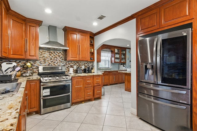 6022 Downwood Forest Dr, Houston, TX 77088 - kitchen featuring wall chimney range hood, light tile patterned floors, visible vents, decorative backsplash, and stainless steel appliances
