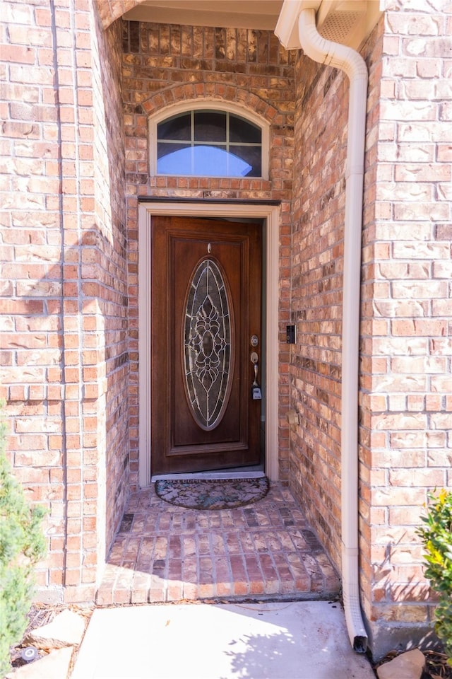 property entrance featuring brick siding