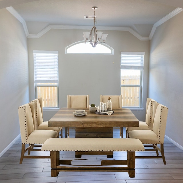 dining room with lofted ceiling, a healthy amount of sunlight, visible vents, and light wood-type flooring