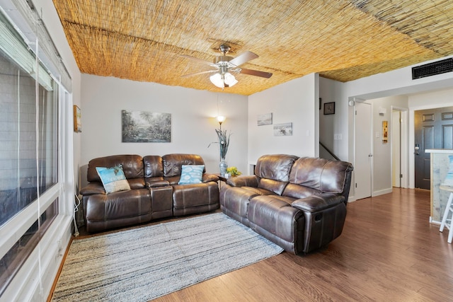 living area featuring visible vents, a ceiling fan, and wood finished floors