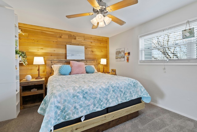bedroom featuring carpet flooring, ceiling fan, wood walls, and baseboards