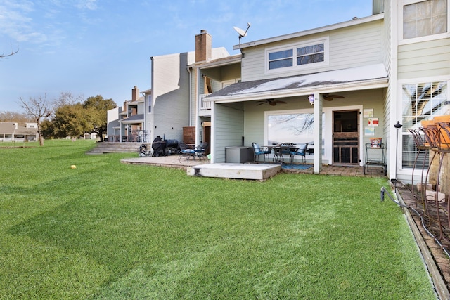 rear view of house with a yard, a patio, a ceiling fan, and a chimney