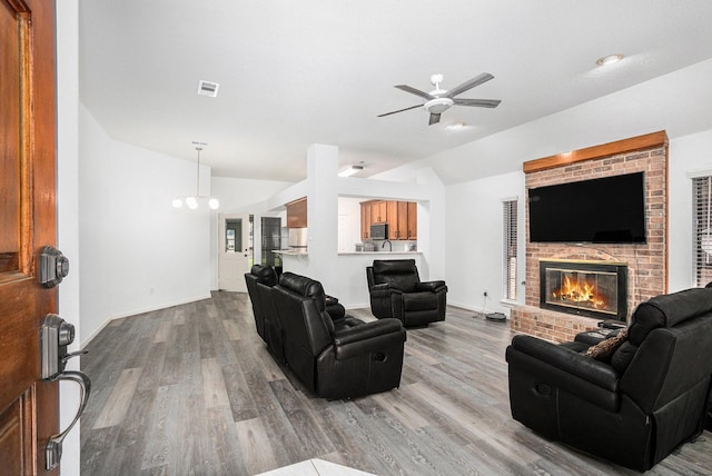 39 Alexander Ct, Angleton, TX 77515 - living area with vaulted ceiling, a ceiling fan, wood finished floors, a fireplace, and baseboards