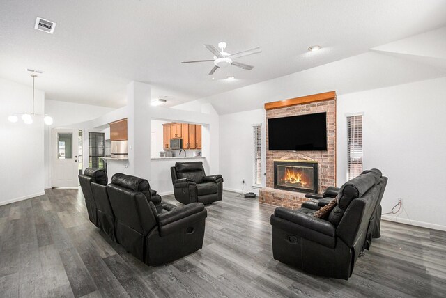 39 Alexander Ct, Angleton, TX 77515 - living room featuring vaulted ceiling, dark wood finished floors, a ceiling fan, a fireplace, and baseboards