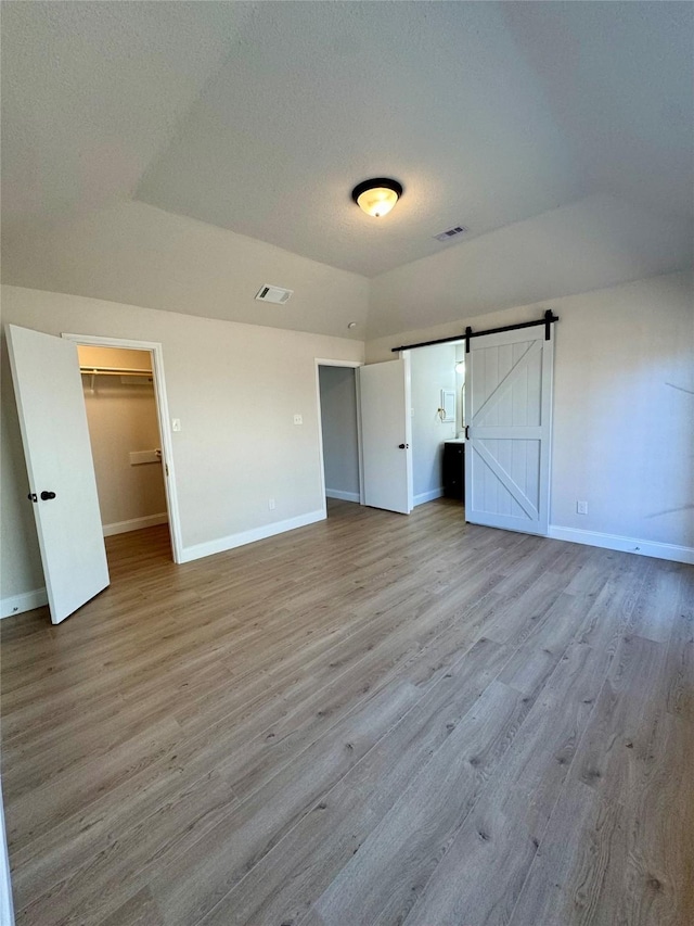 unfurnished bedroom with wood finished floors, visible vents, and baseboards
