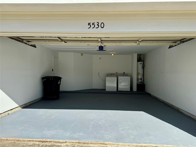 garage with water heater, independent washer and dryer, and a garage door opener