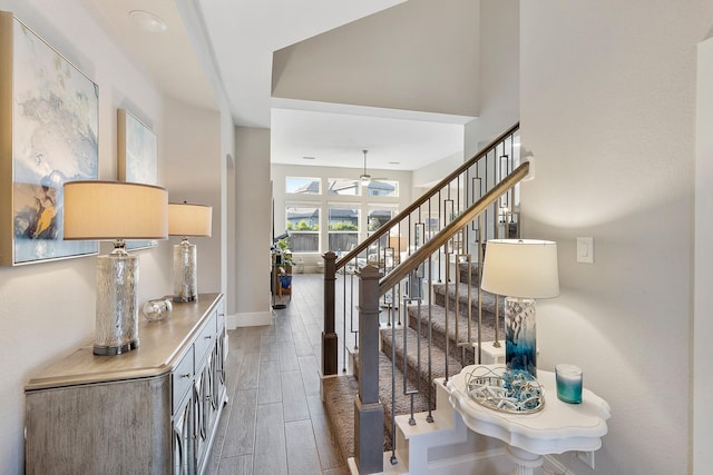 entryway with a ceiling fan, stairway, wood finished floors, and baseboards