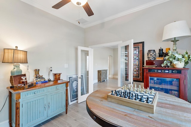 interior space with light wood-type flooring, french doors, baseboards, and crown molding
