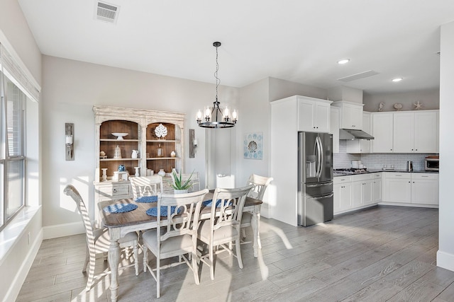 dining area featuring recessed lighting, an inviting chandelier, visible vents, light wood-style flooring, and baseboards