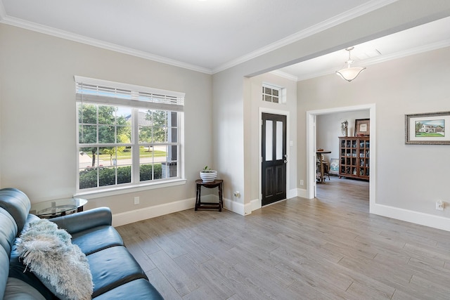 living area featuring ornamental molding, baseboards, and light wood-style floors