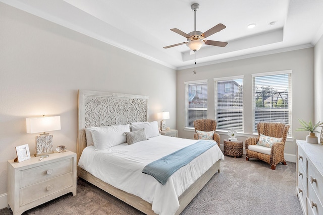 bedroom with light colored carpet, ceiling fan, crown molding, and a tray ceiling