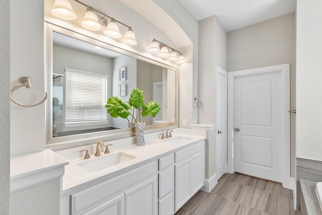 full bathroom with double vanity and a sink