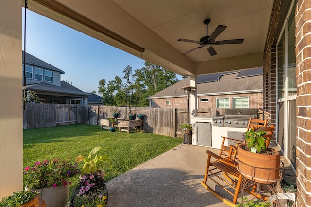 view of yard featuring a patio, a fenced backyard, a ceiling fan, and exterior kitchen