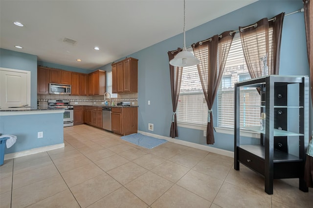 kitchen featuring backsplash, appliances with stainless steel finishes, a wealth of natural light, and visible vents