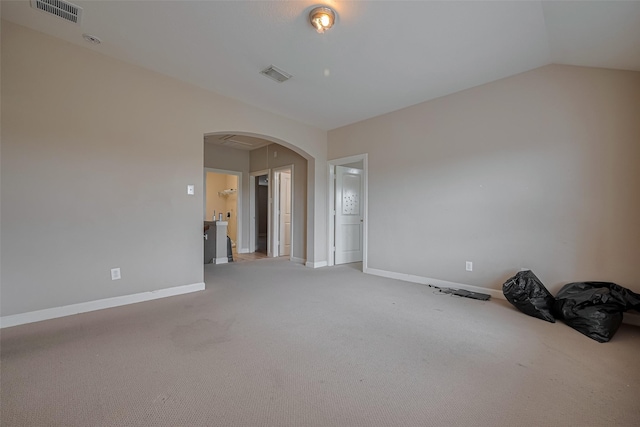 unfurnished room featuring visible vents, arched walkways, and baseboards
