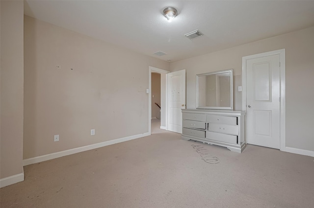 unfurnished bedroom with carpet floors, baseboards, and visible vents