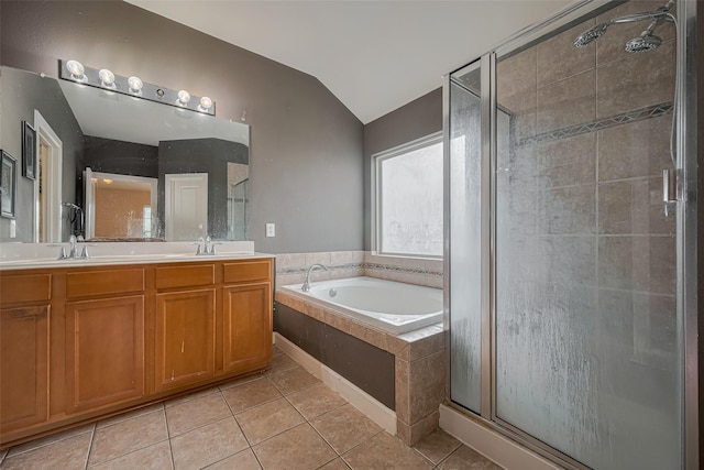 bathroom featuring a garden tub, double vanity, tile patterned floors, a shower stall, and vaulted ceiling