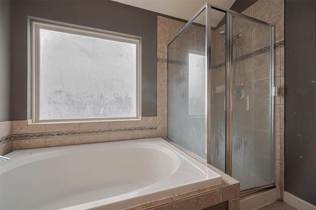 bathroom with a stall shower and a garden tub