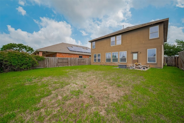 back of house featuring a lawn and a fenced backyard