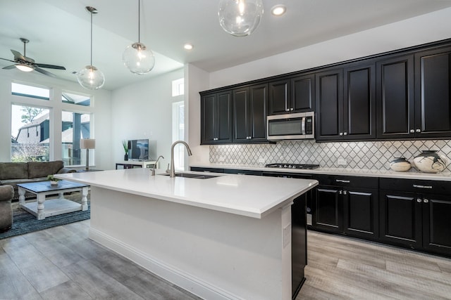 16958 Chapel Knox Dr, Humble, TX 77346 - kitchen with a ceiling fan, a sink, stainless steel appliances, dark cabinetry, and open floor plan