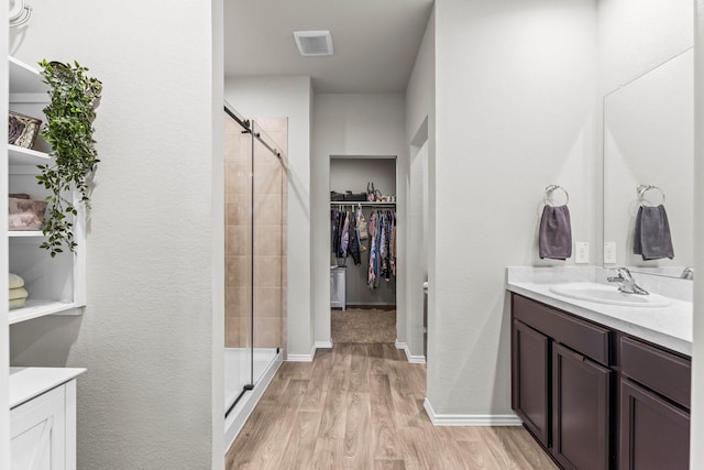 15038 Eastern Wood Rd, Magnolia, TX 77354 - full bathroom featuring a walk in closet, a shower stall, wood finished floors, and visible vents