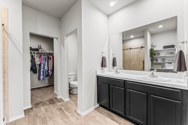 15038 Eastern Wood Rd, Magnolia, TX 77354 - bathroom featuring a spacious closet, a shower stall, a sink, and wood finished floors