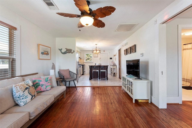2216 Grover Ave, Galveston, TX 77551 - living room with wood-type flooring, ceiling fan, and a chandelier