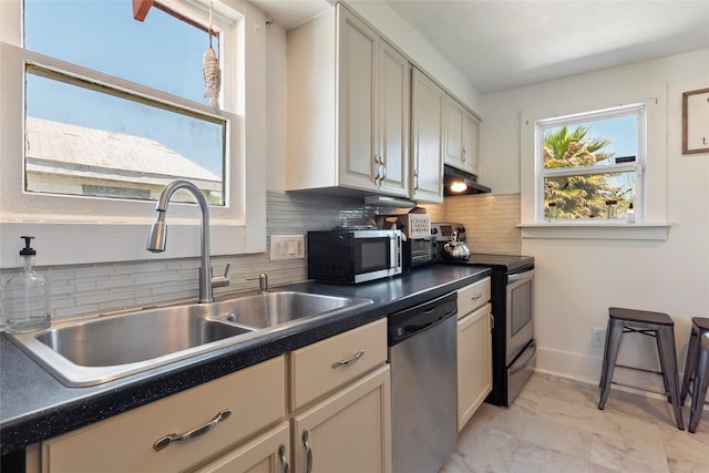 2216 Grover Ave, Galveston, TX 77551 - kitchen with stainless steel appliances, plenty of natural light, a sink, and dark countertops