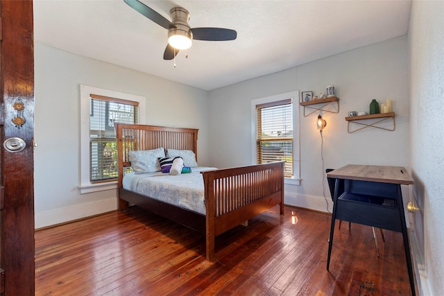 2216 Grover Ave, Galveston, TX 77551 - bedroom featuring multiple windows, hardwood / wood-style floors, baseboards, and a ceiling fan