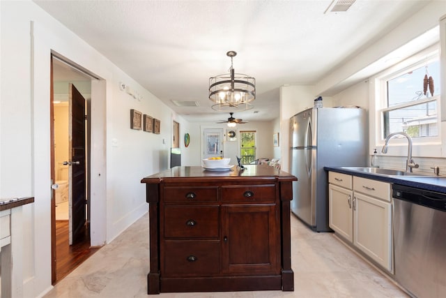 2216 Grover Ave, Galveston, TX 77551 - kitchen with appliances with stainless steel finishes, a sink, a chandelier, dark countertops, and healthy amount of natural light