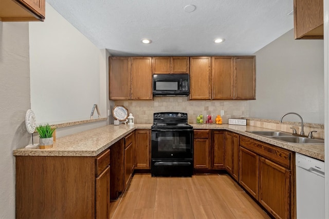 12226 Wild Pine Dr Unit B, Houston, TX 77039 - kitchen featuring black appliances, a sink, light wood-style floors, brown cabinetry, and recessed lighting