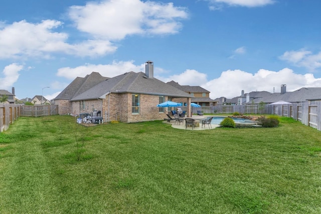 rear view of house featuring brick siding, a lawn, a patio, and a fenced backyard