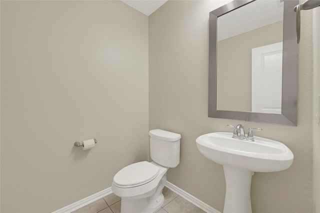 bathroom featuring tile patterned floors, baseboards, and toilet