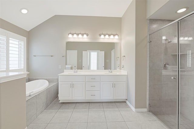 full bathroom with a bath, double vanity, a stall shower, vaulted ceiling, and tile patterned flooring