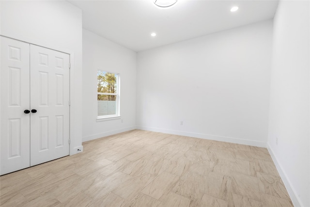 unfurnished bedroom with a closet, baseboards, and recessed lighting