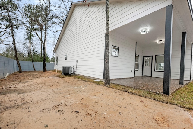 exterior space with a fenced backyard, a patio, and central air condition unit