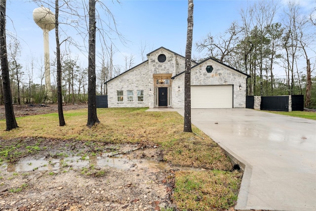 view of front of home with driveway, stone siding, and an attached garage