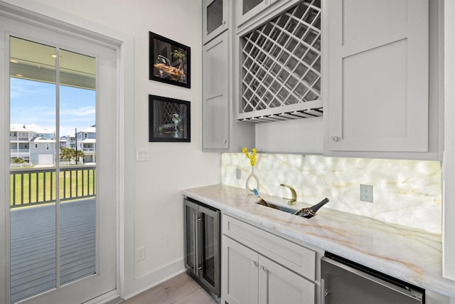 11370 Beachside, Galveston, TX 77554 - bar featuring baseboards, a sink, wet bar, backsplash, and beverage cooler