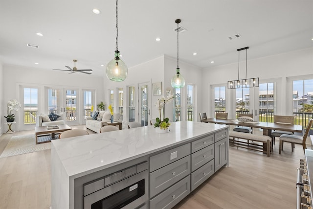 11370 Beachside, Galveston, TX 77554 - kitchen featuring recessed lighting, a center island, gray cabinetry, visible vents, and light wood finished floors