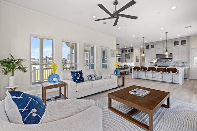 11370 Beachside, Galveston, TX 77554 - living area with crown molding, a ceiling fan, visible vents, recessed lighting, and light wood finished floors