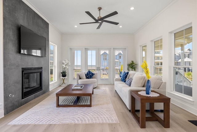 11370 Beachside, Galveston, TX 77554 - living room featuring a large fireplace, ornamental molding, recessed lighting, light wood-style flooring, and ceiling fan