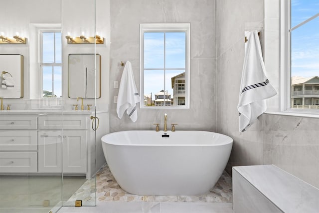 11370 Beachside, Galveston, TX 77554 - full bath with a freestanding bath, double vanity, a sink, and a wealth of natural light