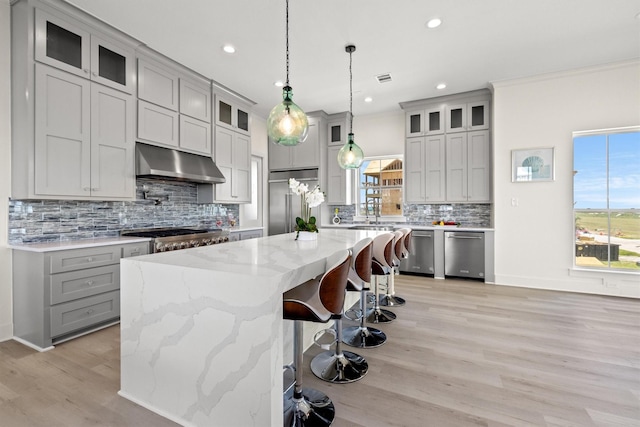 11370 Beachside, Galveston, TX 77554 - kitchen featuring a kitchen island, a healthy amount of sunlight, under cabinet range hood, stainless steel appliances, and gray cabinetry