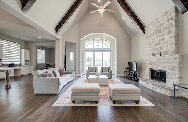living room featuring high vaulted ceiling, beamed ceiling, a fireplace, and dark wood finished floors